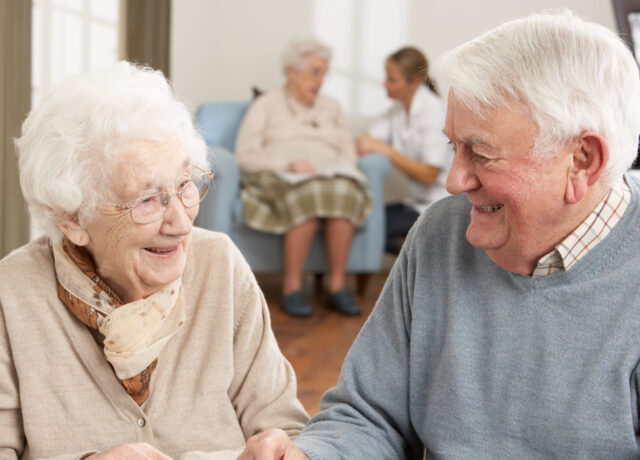 An elderly man and woman laughing with each other