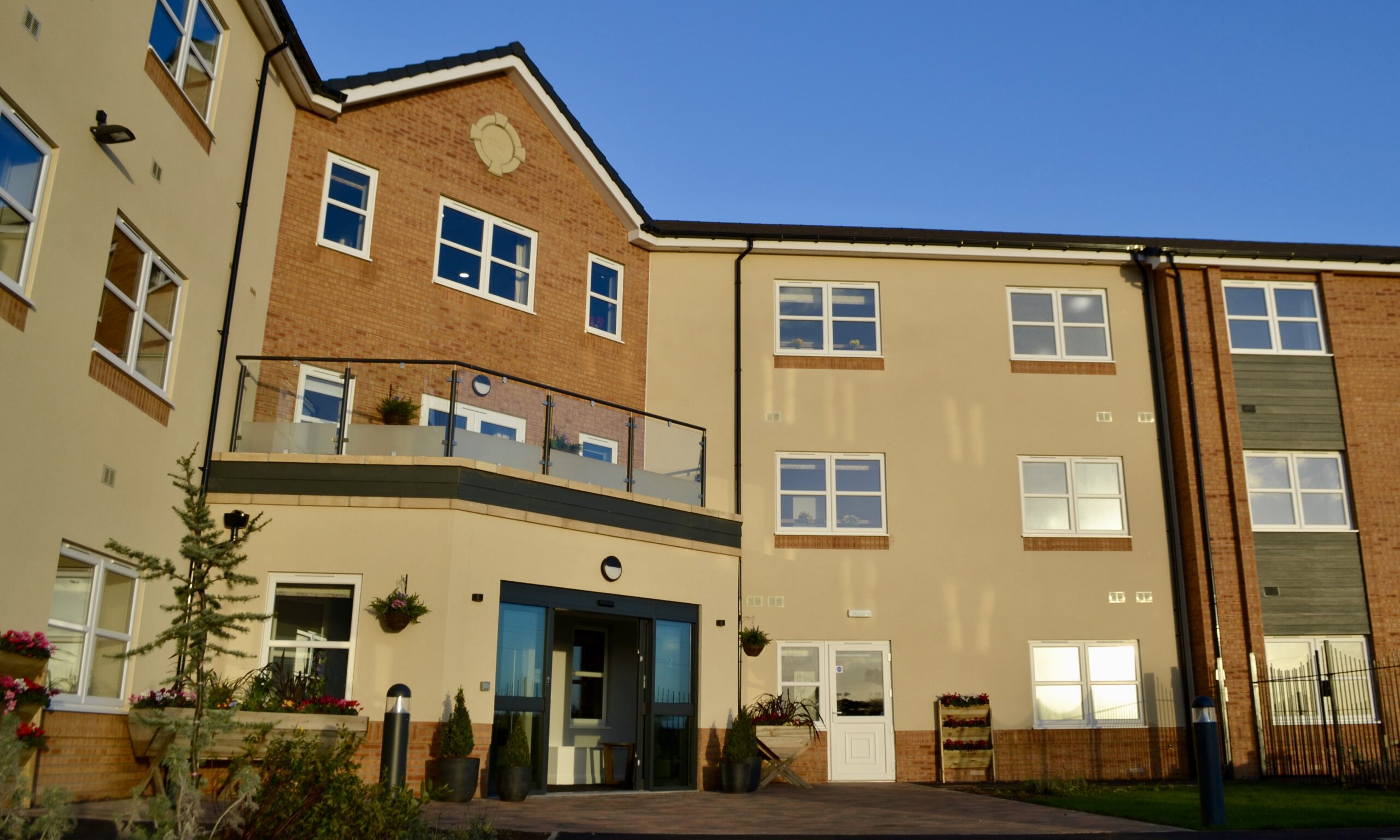 Exterior view of Avocet House Care Home in Boston, featuring a modern building design with large windows and a well-maintained garden area in front.